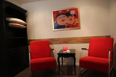 two red chairs and a table in a room at budget rooms Doppenberg in Zandvoort