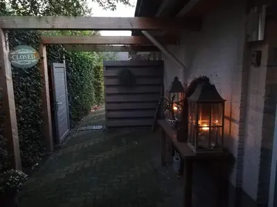 an entrance to a house with a gate and a lantern at Casa Batavia B&B in Lelystad
