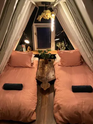 a attic room with two beds and a table at Attic Monkeys Lodge in Amsterdam