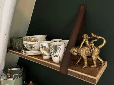 a shelf with dishes and a gold monkey statue on it at Attic Monkeys Lodge in Amsterdam