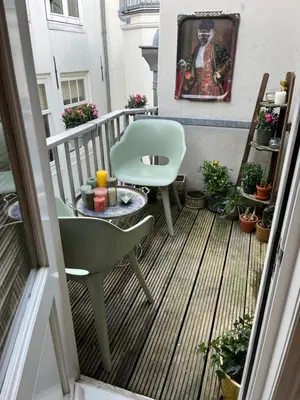 a balcony with a green chair and a table at Attic Monkeys Lodge in Amsterdam