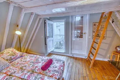 a room with a bed and a ladder and a staircase at Attic Monkeys Lodge in Amsterdam