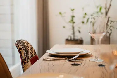 a wooden table with a plate and a glass of wine at Leidse Square 5 star Luxury Apartment in Amsterdam