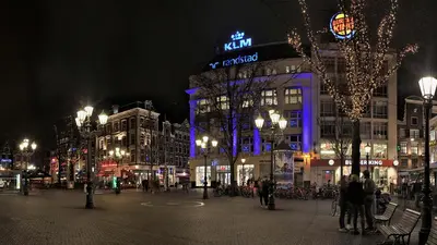 a city street at night with buildings with blue lights at Leidse Square 5 star Luxury Apartment in Amsterdam