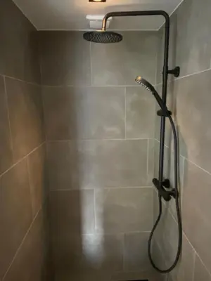 a shower with a shower head in a bathroom at Zilt Noordwijk in Noordwijk aan Zee