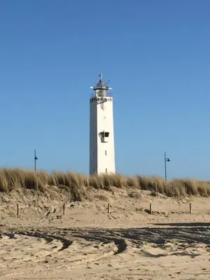 a lighthouse sitting on top of a sandy beach at Zilt Noordwijk in Noordwijk aan Zee