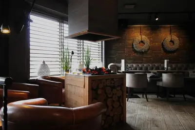a restaurant with leather chairs and a bar with a counter at Best Western Beach Hotel Bergen aan Zee in Bergen aan Zee