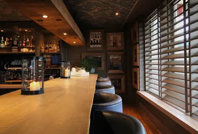 a bar with a row of stools in a restaurant at Best Western Beach Hotel Bergen aan Zee in Bergen aan Zee