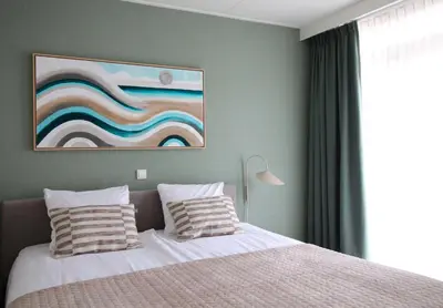 a bedroom with a bed and a painting on the wall at Best Western Beach Hotel Bergen aan Zee in Bergen aan Zee