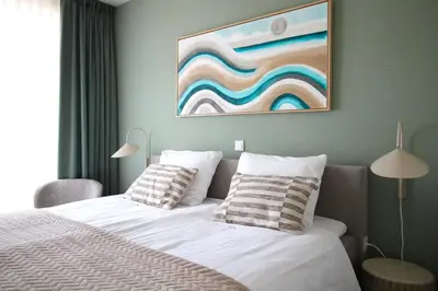 a bedroom with a bed and a painting on the wall at Best Western Beach Hotel Bergen aan Zee in Bergen aan Zee