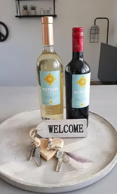 two bottles of wine and keys on a plate at INTIKA Beach House in Zandvoort