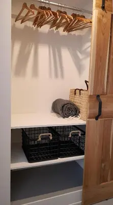 a closet with two baskets on a shelf at INTIKA Beach House in Zandvoort
