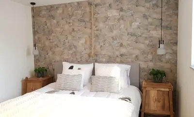 a bedroom with a bed with white sheets and pillows at INTIKA Beach House in Zandvoort