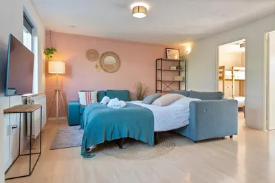 a bedroom with a bed and a blue couch at Spacious Family Holiday Home (7p), Free indoor parking in Zandvoort