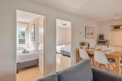 a living room with a table and a bedroom at Spacious Family Holiday Home (7p), Free indoor parking in Zandvoort