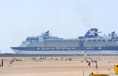 a cruise ship on the beach with people on the beach at CHALETS IN THE DUNES nearby the beach in IJmuiden