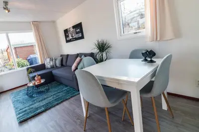 a living room with a white table and chairs at CHALETS IN THE DUNES nearby the beach in IJmuiden