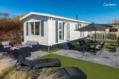 a small white house with a table and chairs at CHALETS IN THE DUNES nearby the beach in IJmuiden
