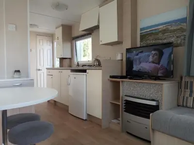 a kitchen with a tv on a counter with a table at CHALETS IN THE DUNES nearby the beach in IJmuiden