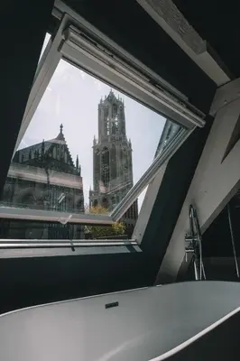 a window in a bathroom with a view of a building at Anne&Max Boutique Hotel in Utrecht