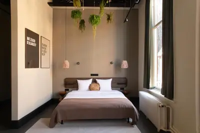 a bedroom with a bed and a large window at Anne&Max Boutique Hotel in Utrecht
