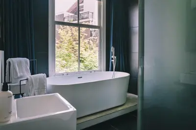 a bathroom with a large tub and a window at Anne&Max Boutique Hotel in Utrecht
