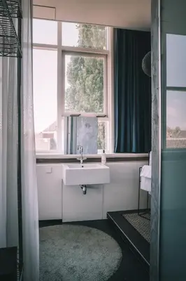 a bathroom with a sink and a window at Anne&Max Boutique Hotel in Utrecht