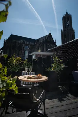 a patio with a table and chairs and a building at Anne&Max Boutique Hotel in Utrecht