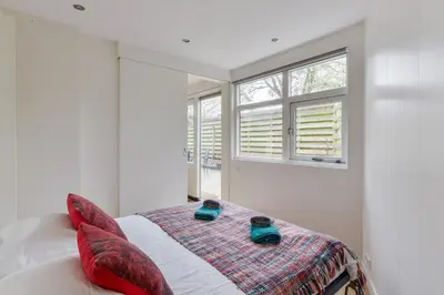 a bedroom with a bed with red pillows and a window at Modern Bungalow Zandvoortselaan in Zandvoort