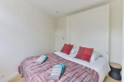 a bedroom with a bed with red and blue pillows at Modern Bungalow Zandvoortselaan in Zandvoort