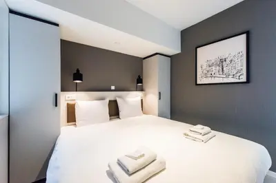 a bedroom with a white bed with two towels on it at YAYS Amsterdam East by Numa in Amsterdam