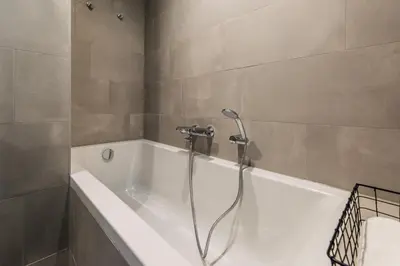 a bathroom with a bath tub with a shower at YAYS Amsterdam East by Numa in Amsterdam