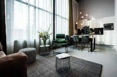 a living room with a couch and a table with chairs at YAYS Amsterdam East by Numa in Amsterdam