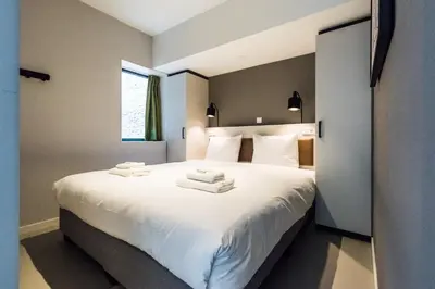 a bedroom with a large white bed with towels on it at YAYS Amsterdam East by Numa in Amsterdam