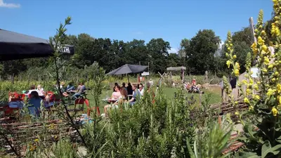a group of people sitting in a field at Amsterdam Farm Lodge in Amsterdam
