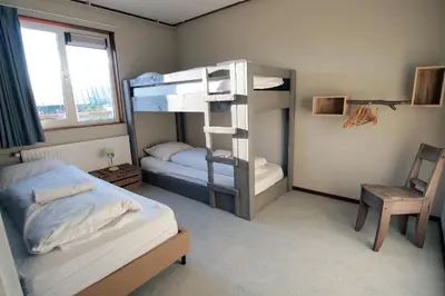 a bedroom with two bunk beds and a chair at Amsterdam Farm Lodge in Amsterdam