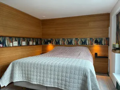 a bedroom with a bed and wooden walls at Houseboat Amsterdam in Amsterdam
