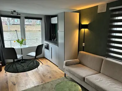 a living room with a couch and a table at Houseboat Amsterdam in Amsterdam