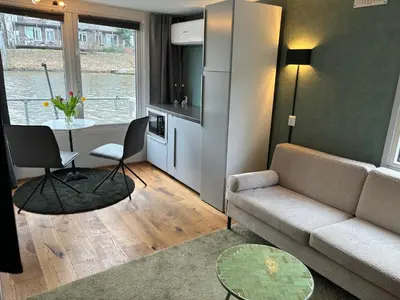 a living room with a couch and a table at Houseboat Amsterdam in Amsterdam