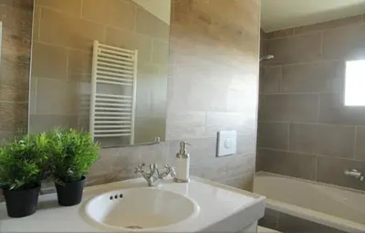 a bathroom with a sink and a mirror and a tub at Cozy Cottage in Warmenhuizen