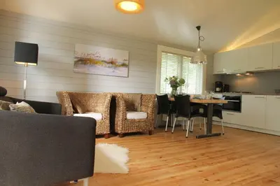 a living room with a couch and a table with chairs at Cozy Cottage in Warmenhuizen