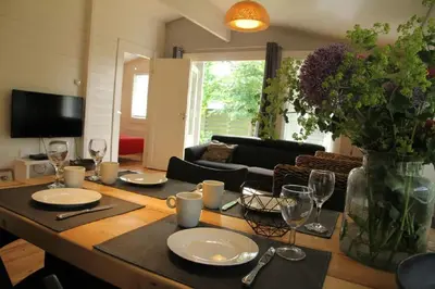 a living room with a table with plates and wine glasses at Cozy Cottage in Warmenhuizen