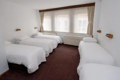 a row of white beds in a room at Hotel Ben Centre in Amsterdam