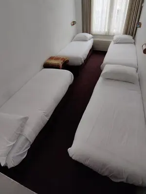 a row of white beds in a room at Hotel Ben Centre in Amsterdam