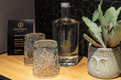 a bottle of water and glasses on a table at Boutique Suites Lisse - Keukenhof in Lisse