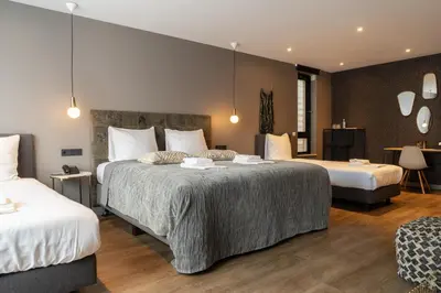 a hotel room with two beds and a living area at Boutique Suites Lisse - Keukenhof in Lisse