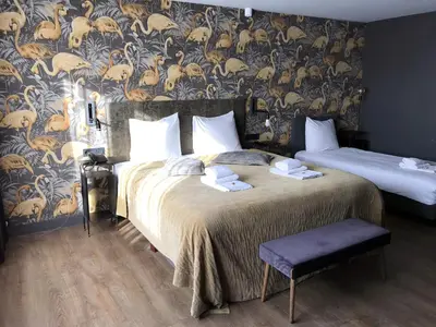 a bedroom with two beds and a wall with a wallpaper at Boutique Suites Lisse - Keukenhof in Lisse