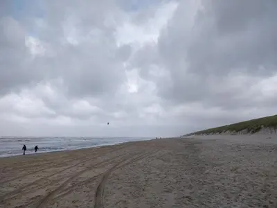 a beach with two people flying a kite at Boutique Suites Lisse - Keukenhof in Lisse