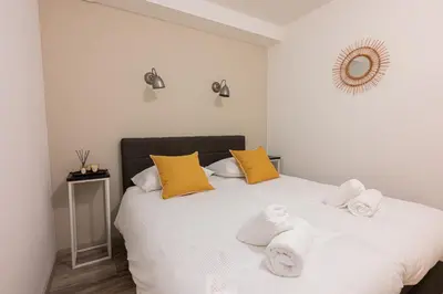 a bedroom with a white bed with towels on it at La Chatelaine in Egmond aan Zee