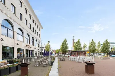 a courtyard with tables and chairs and a building at Authentic Dutch Houseboat in Amsterdam Zuid in Amsterdam